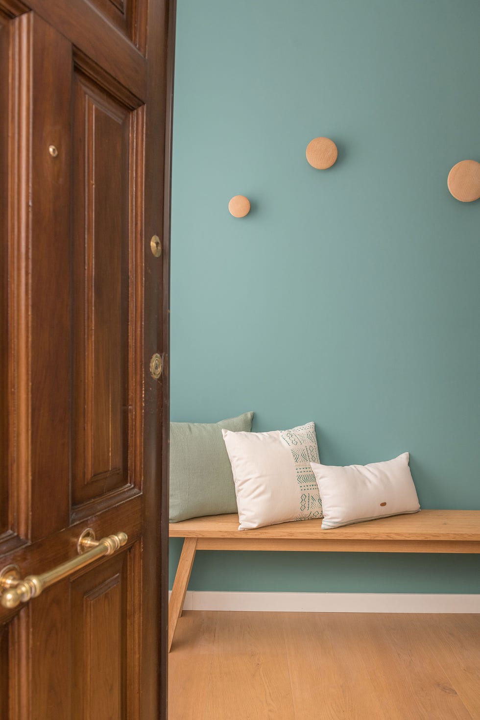 recibidor con banco de madera y pared verde