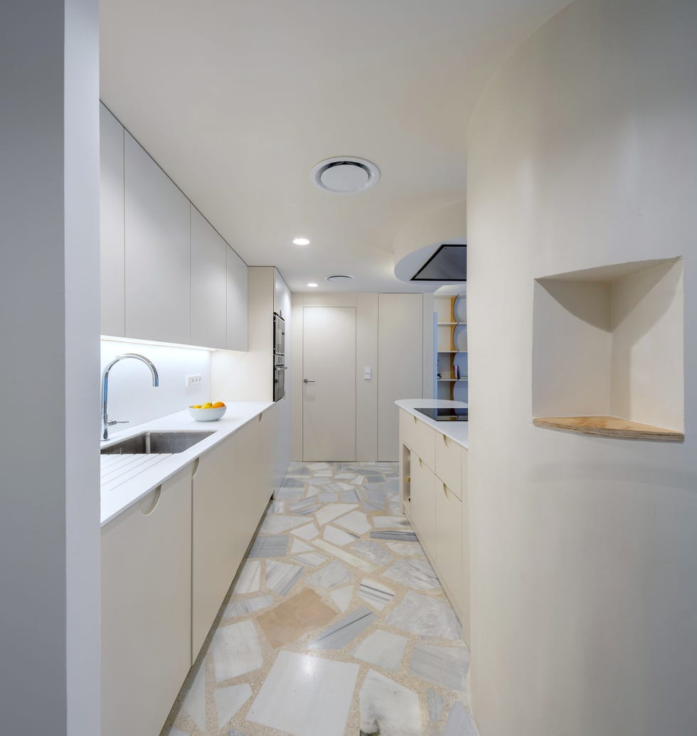 cocina blanca moderna con isla central de diseño ovalado