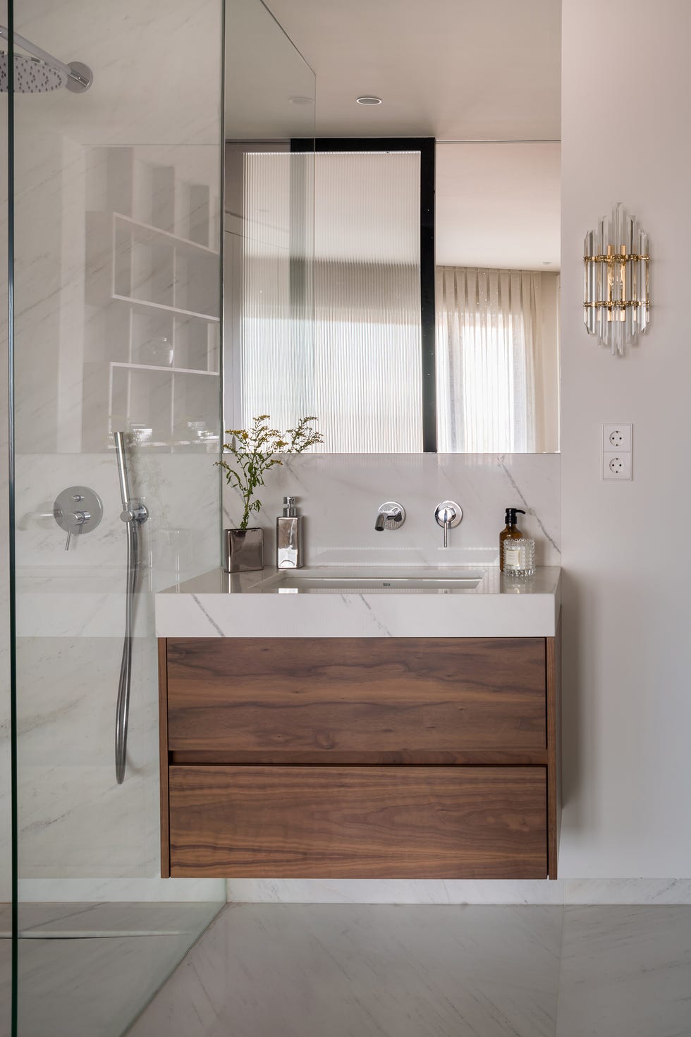 baño moderno con revestimientos de mármol y mueble volado de madera