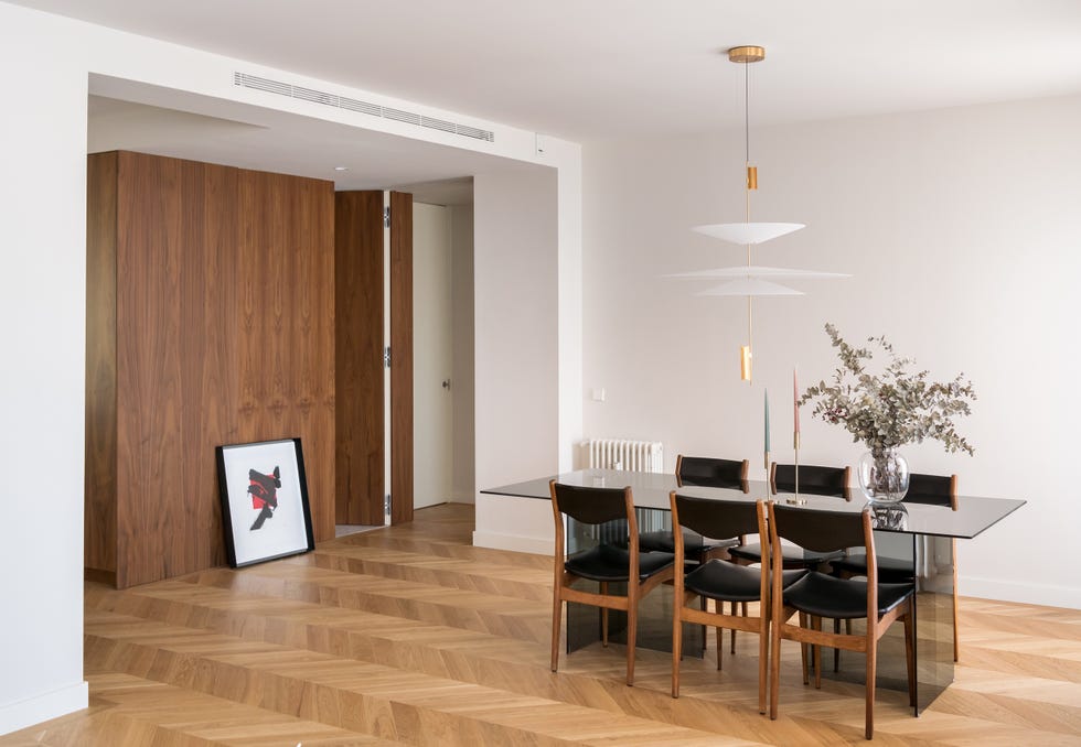 comedor con mesa de cristal y sillas de madera y piel negra