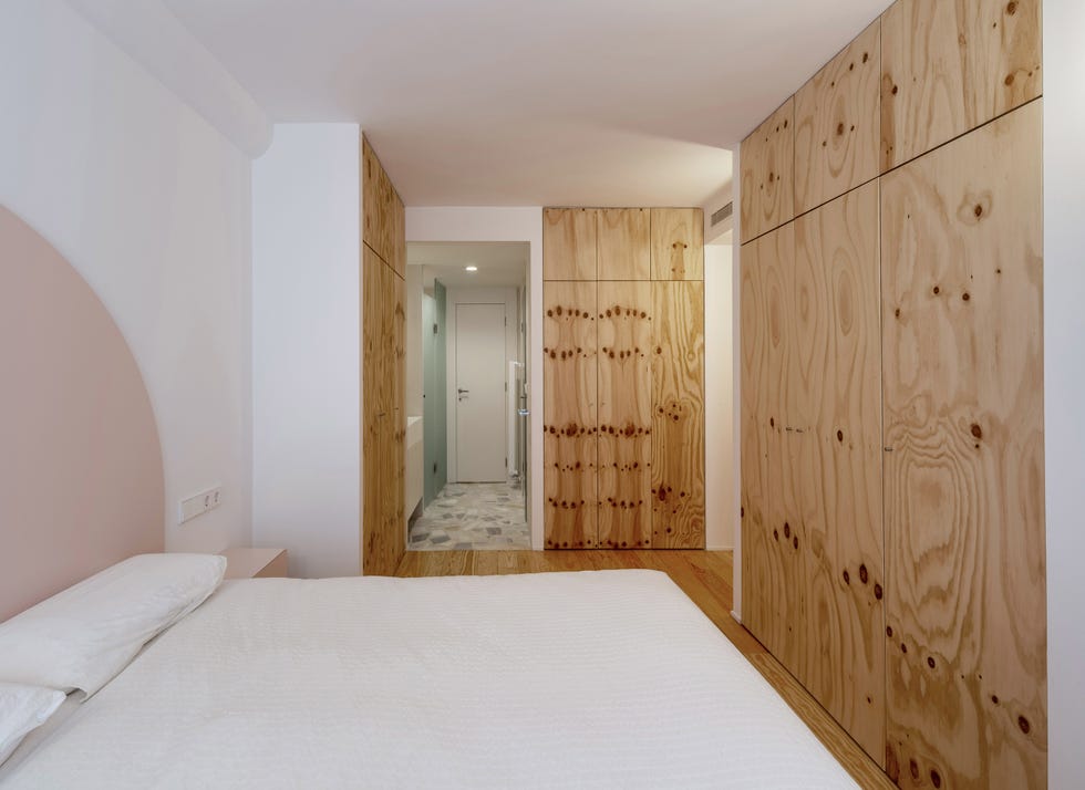 dormitorio con armarios de madera de pino y cabecero en forma de media luna