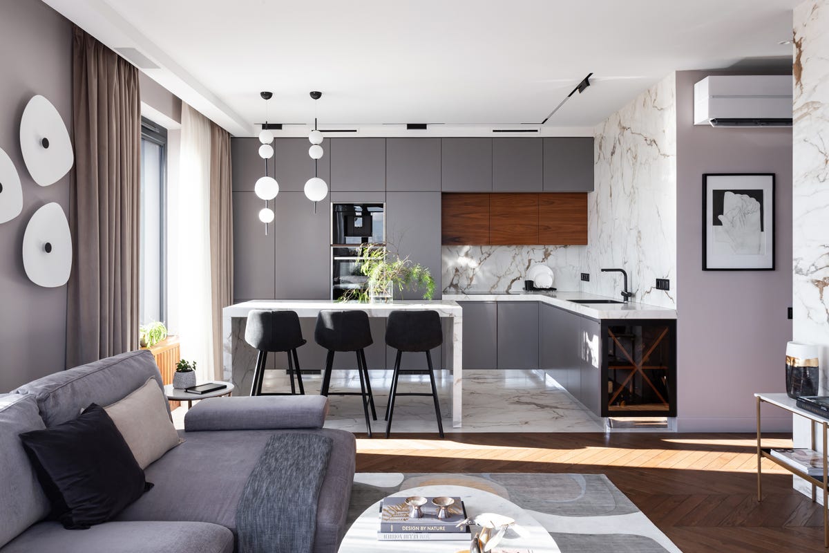 cocina con isla central de diseño moderno en gris abierta al salón