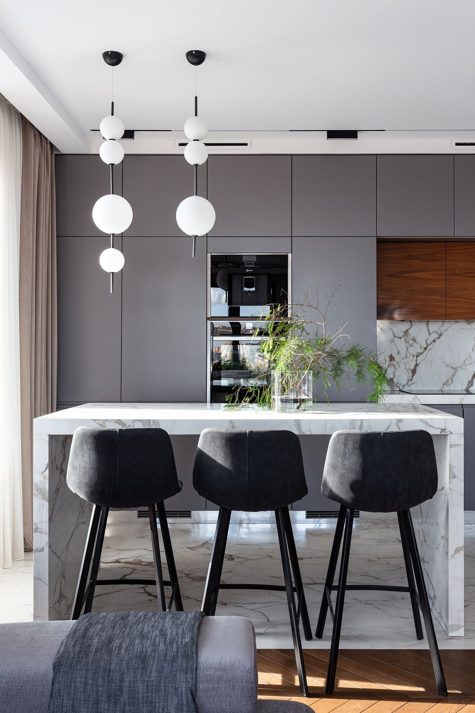cocina con isla central de diseño moderno en gris abierta al salón