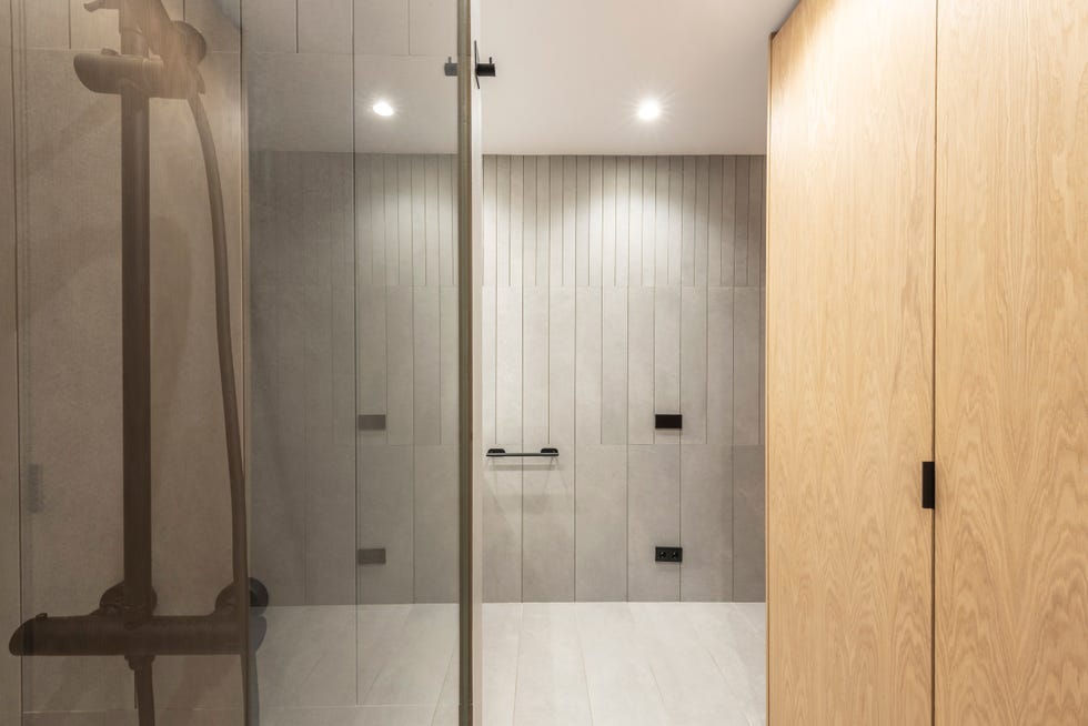 baño moderno con revestimiento de porcelánico gris y armario de roble