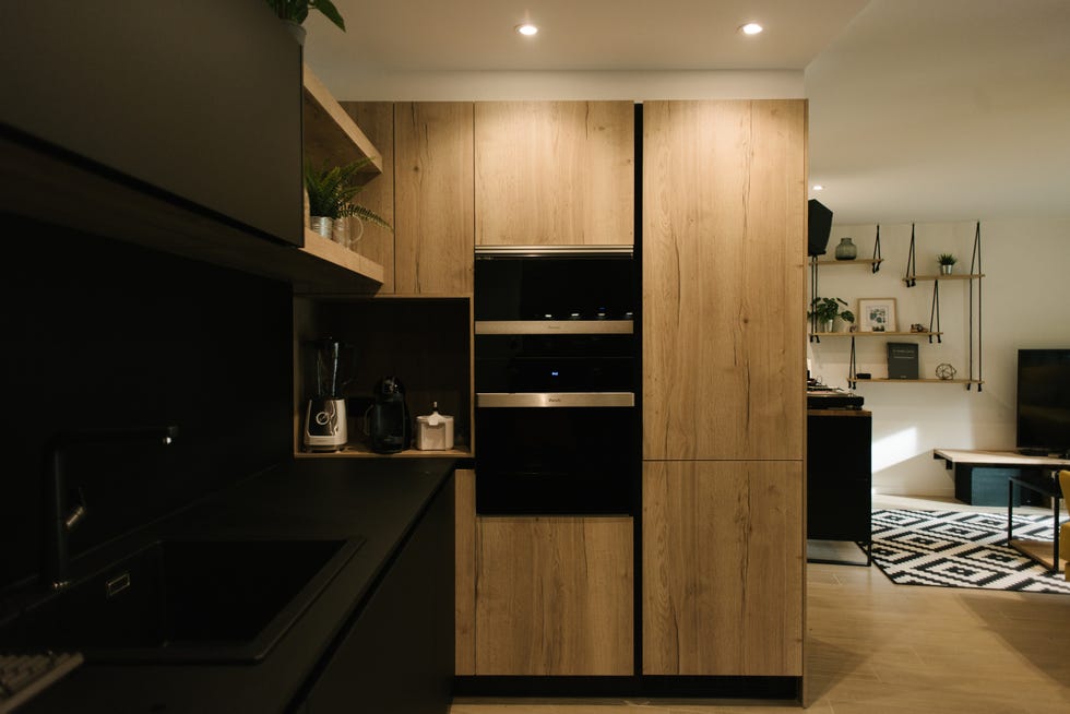 cocina moderna abierta con armarios de color negro y en madera