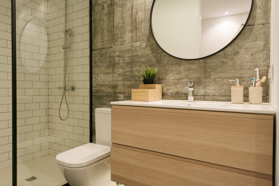 baño moderno con pared de hormigón y ducha con azulejos tipo metro blancos