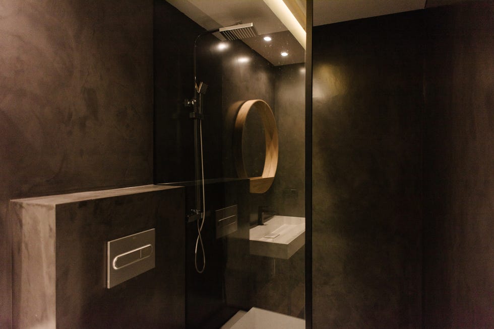 baño moderno con ducha y revestimiento de microcemento gris