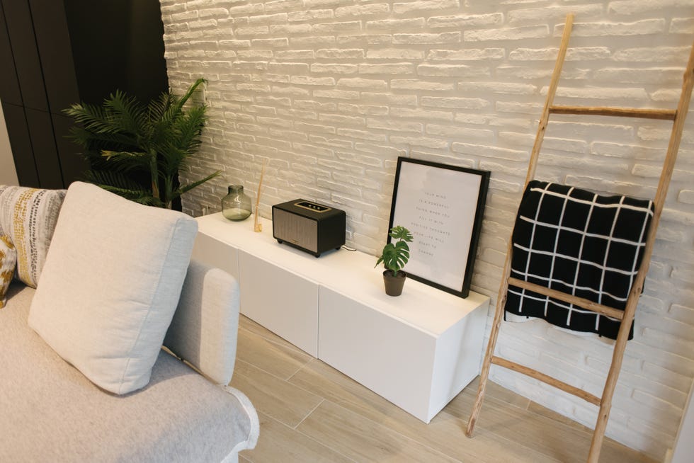 mueble de salón nórdico en color blanco y pared de ladrillo visto pintada en blanco