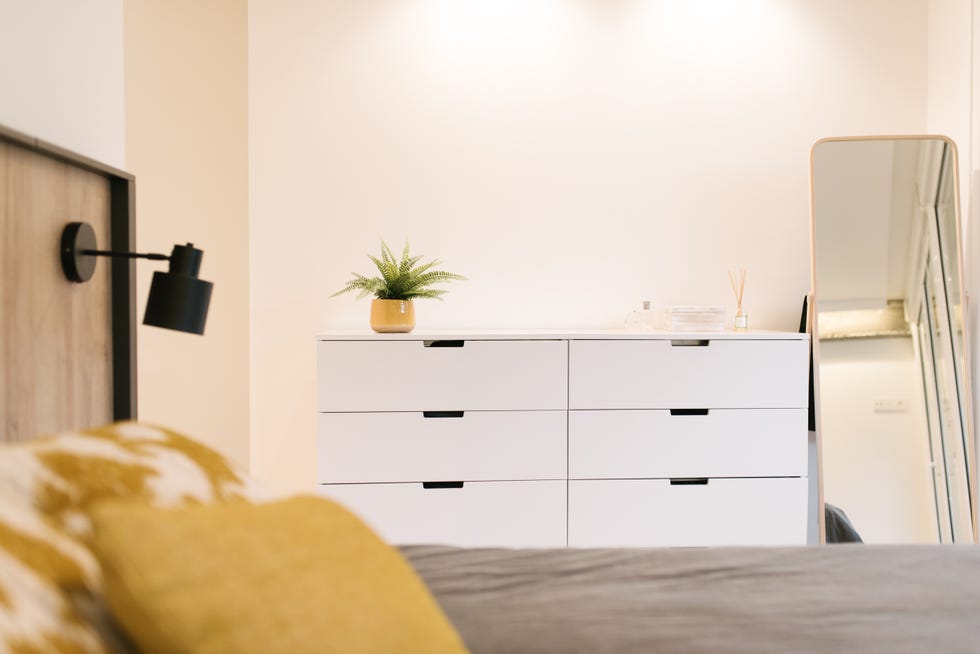 dormitorio moderno con cabecero de madera y cómoda blanca