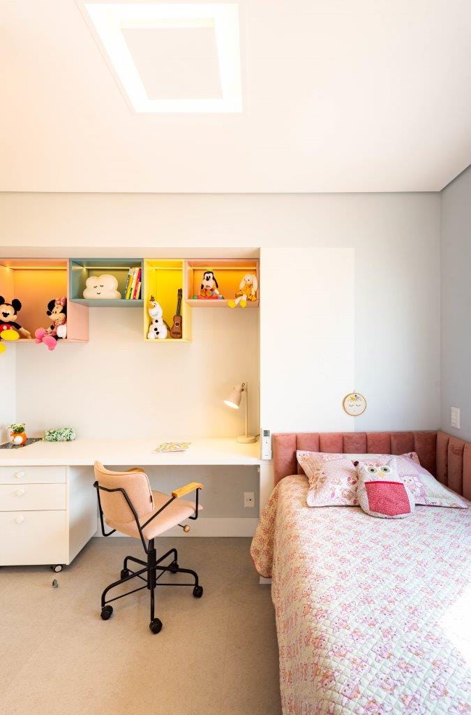 habitación infantil con escritorio y cama con cabecero de terciopelo rosa