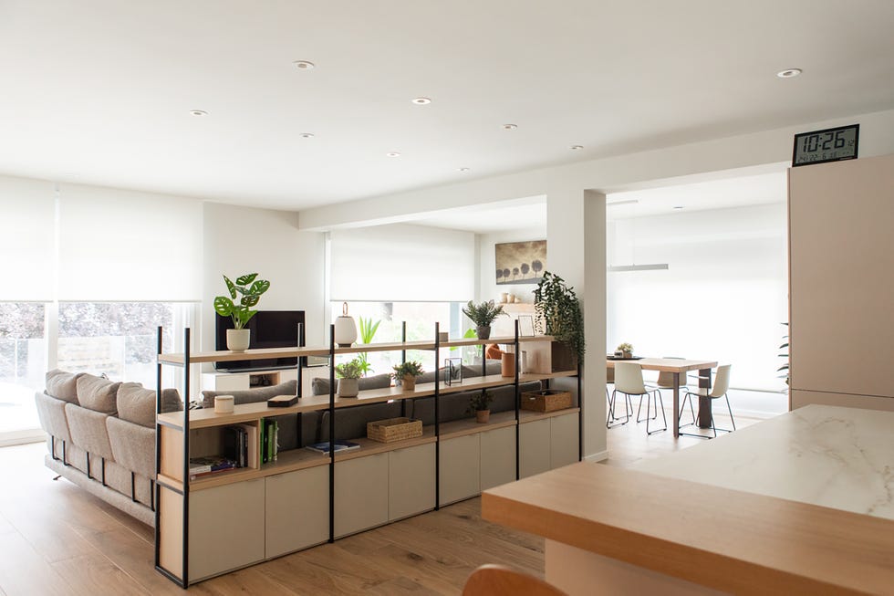 salón comedor separado de la cocina por una estantería