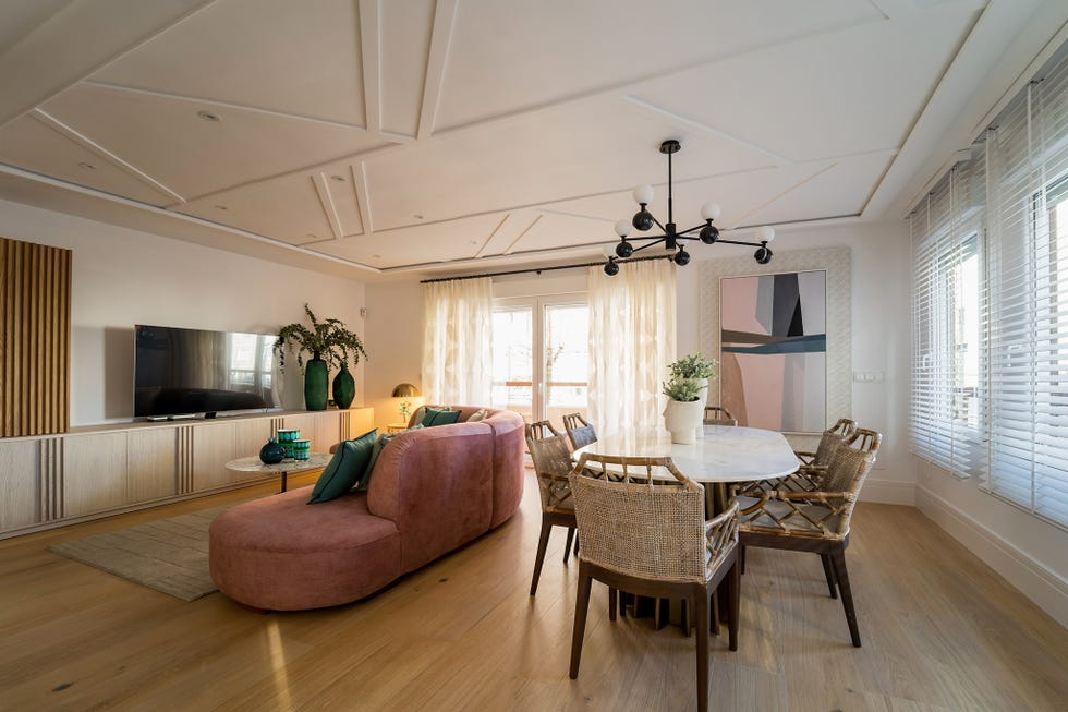 salón comedor con sofá de terciopelo rosa y mesa con sobre de mármol
