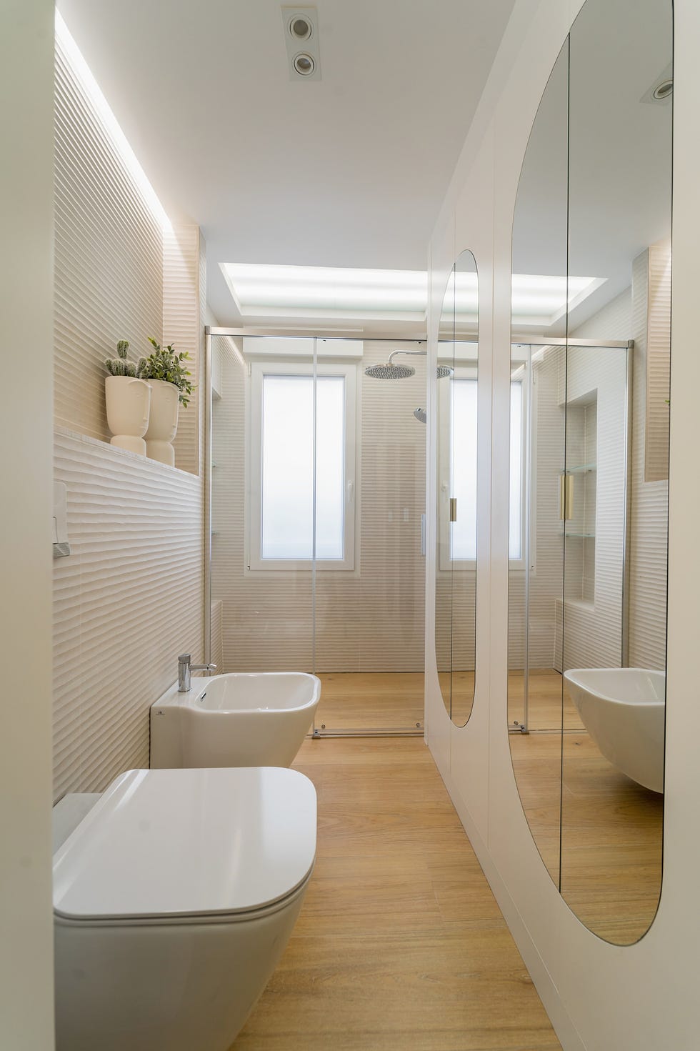baño con ducha, suelo de madera y pared con revestimiento cerámico