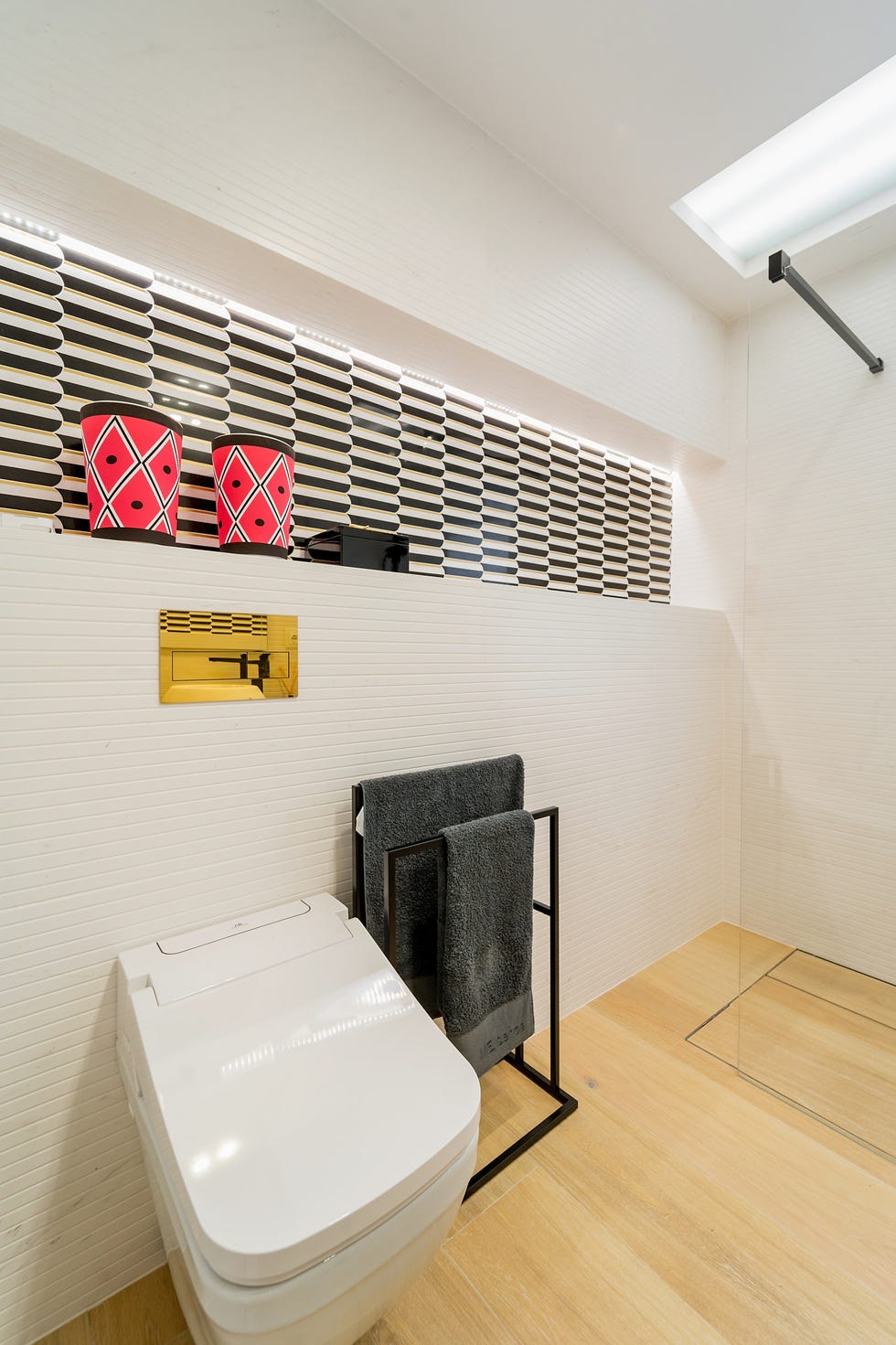 baño con pared revestida en blanco y franja de azulejos en blanco y negro