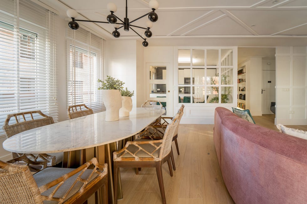 salón comedor con sofá de terciopelo rosa y mesa con sobre de mármol