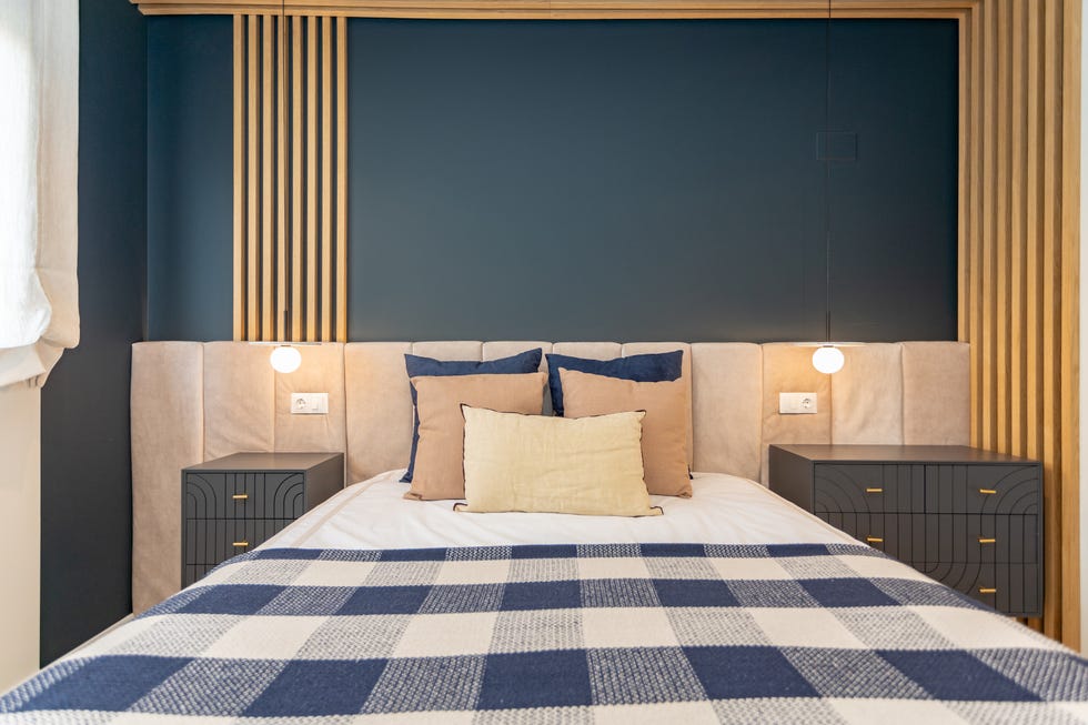 dormitorio con cabecero acolchado en color beige y mesitas de noche de estilo art déco