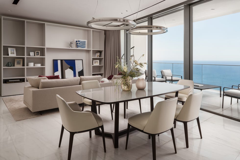 salón comedor en tonos neutros con acceso a la terraza frente al mar