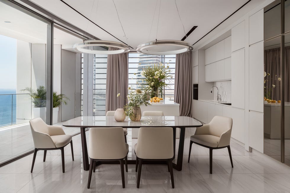 mesa de comedor con sobre de cristal y sillas beige