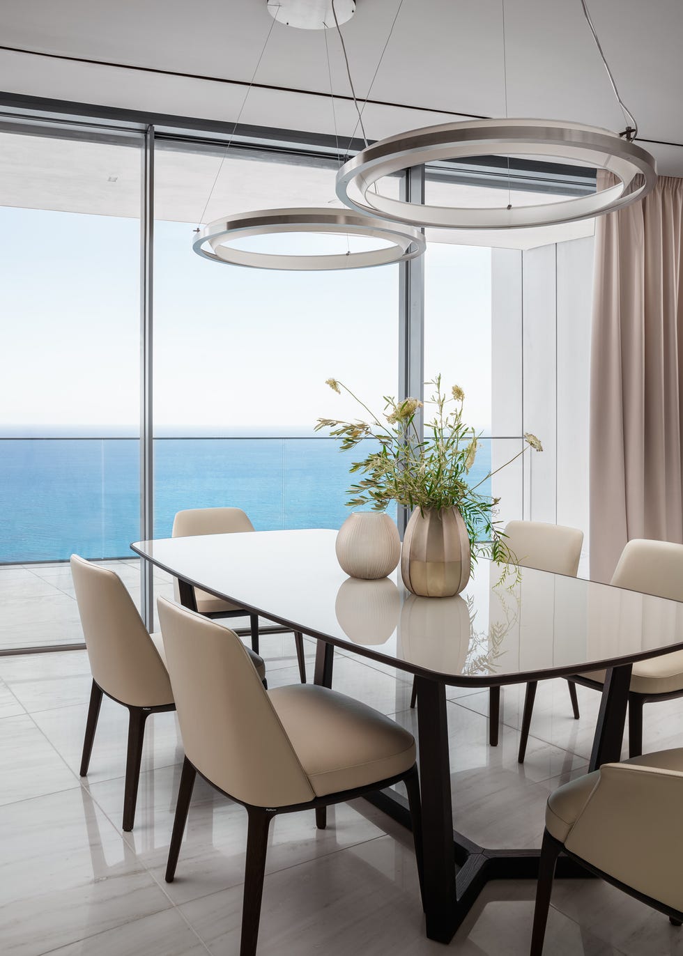 mesa de comedor con sobre de cristal y sillas beige