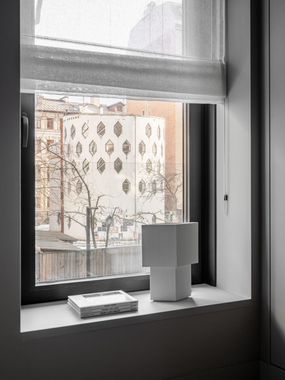 ventana decorada con lámpara de mesa blanca y libros