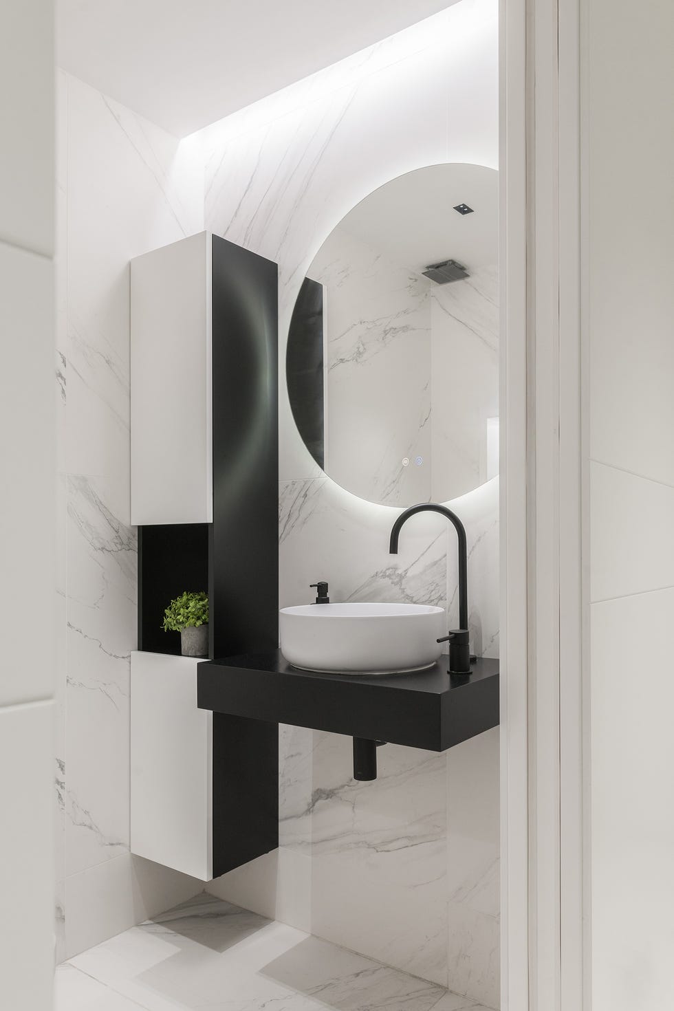 baño con lavabo volado y revestimientos de mármol