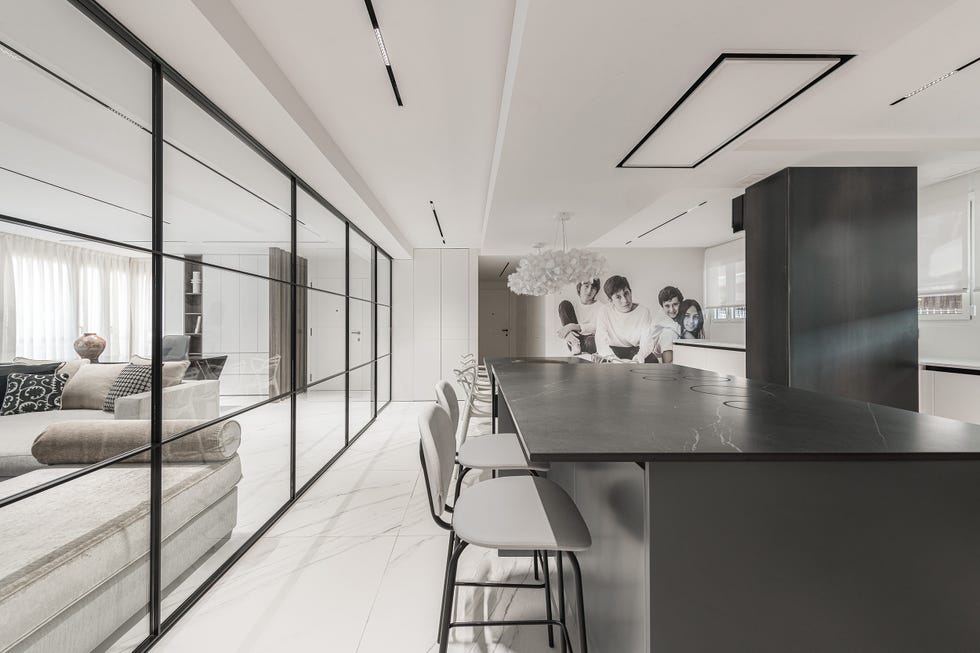 cocina con isla con mesa de comedor y cerramiento de cristal