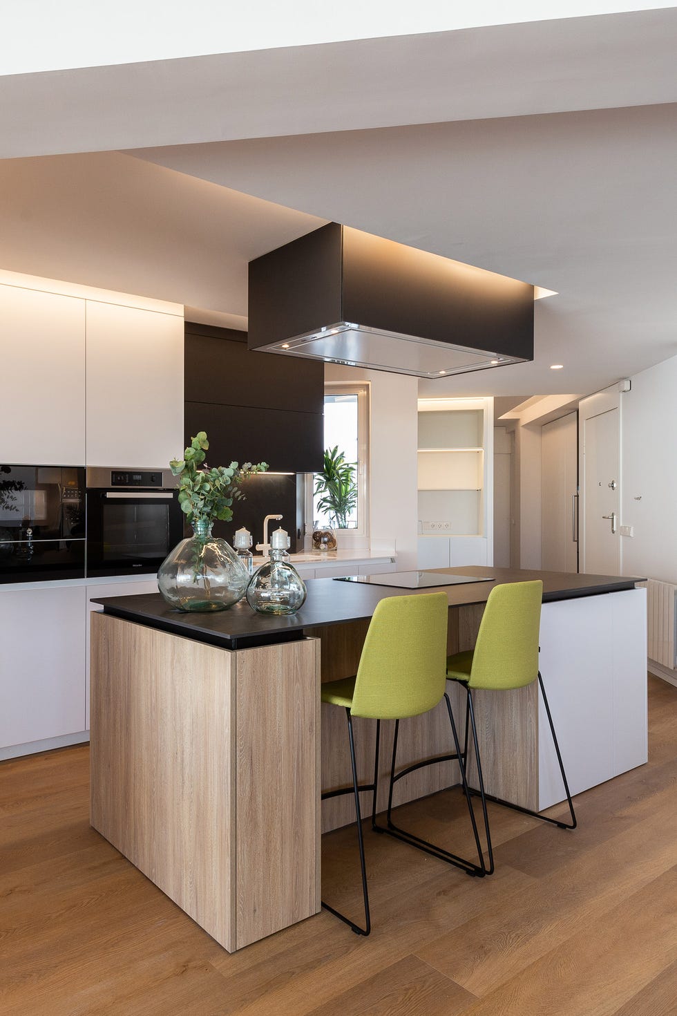 cocina moderna con isla en blanco, negro y madera