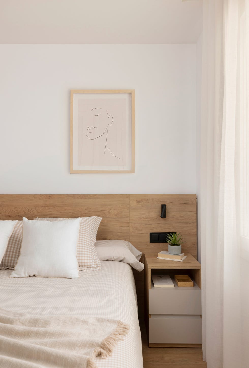 cama con cabecero de madera y mesilla de noche