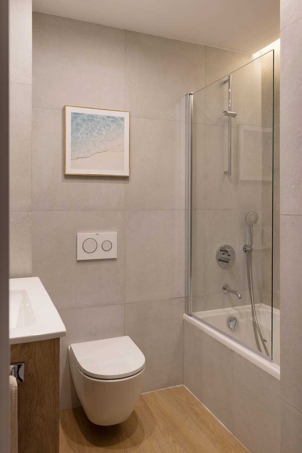 baño con revestimientos cerámicos beige y bañera