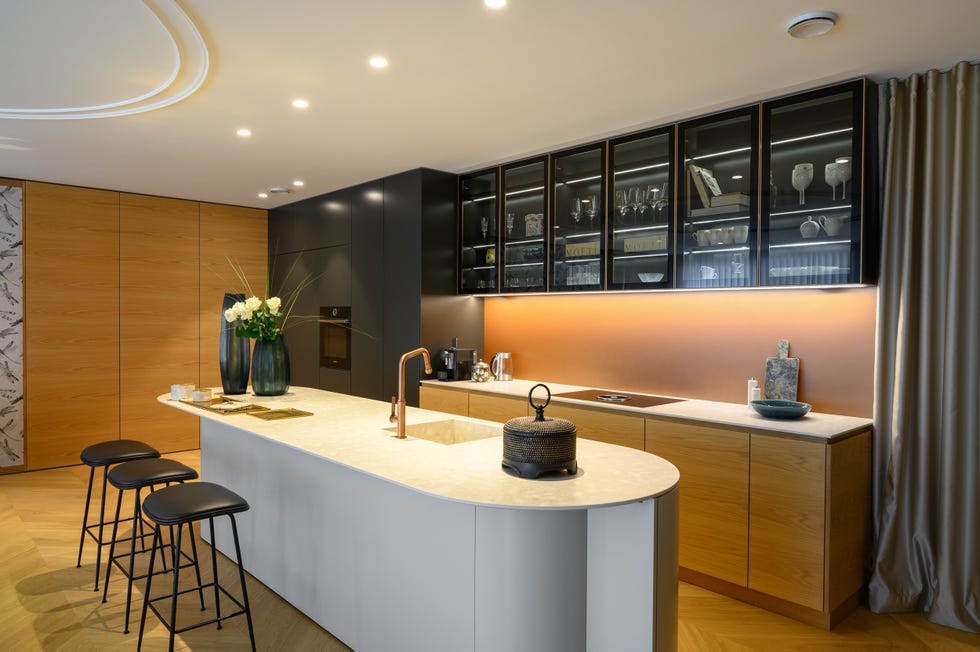 cocina abierta moderna con isla central con encimera de mármol y taburetes negros