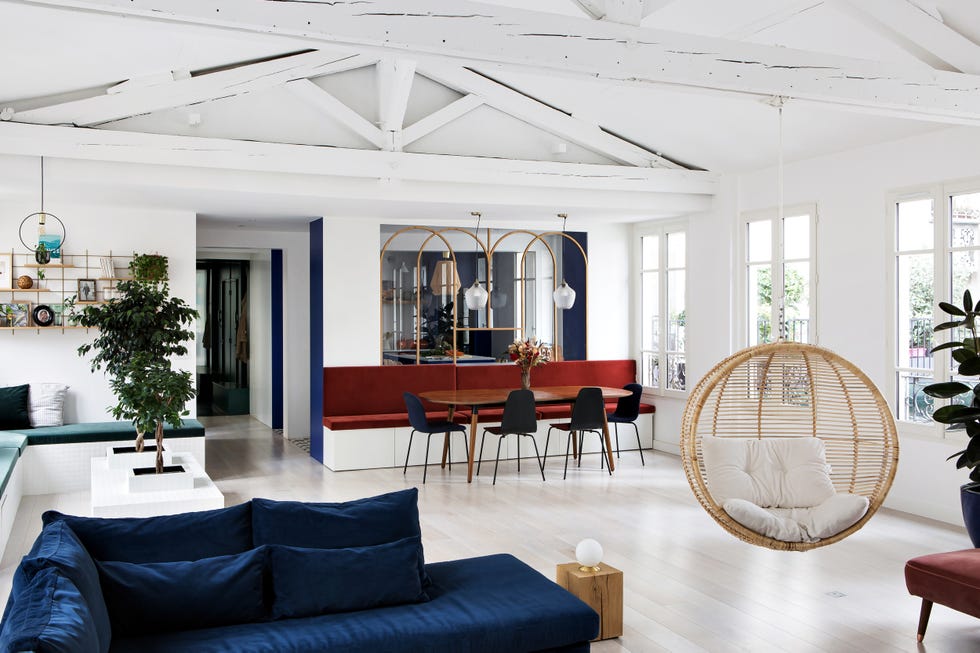 salon comedor con sofá de terciopelo azul y columpio de ratán