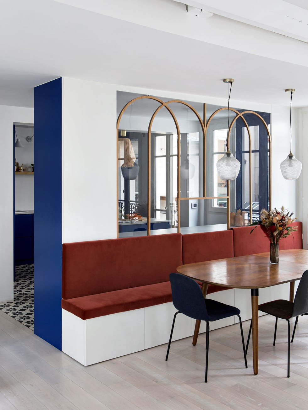 comedor de diseño mid century con banco de obra y asientos de terciopelo terracota