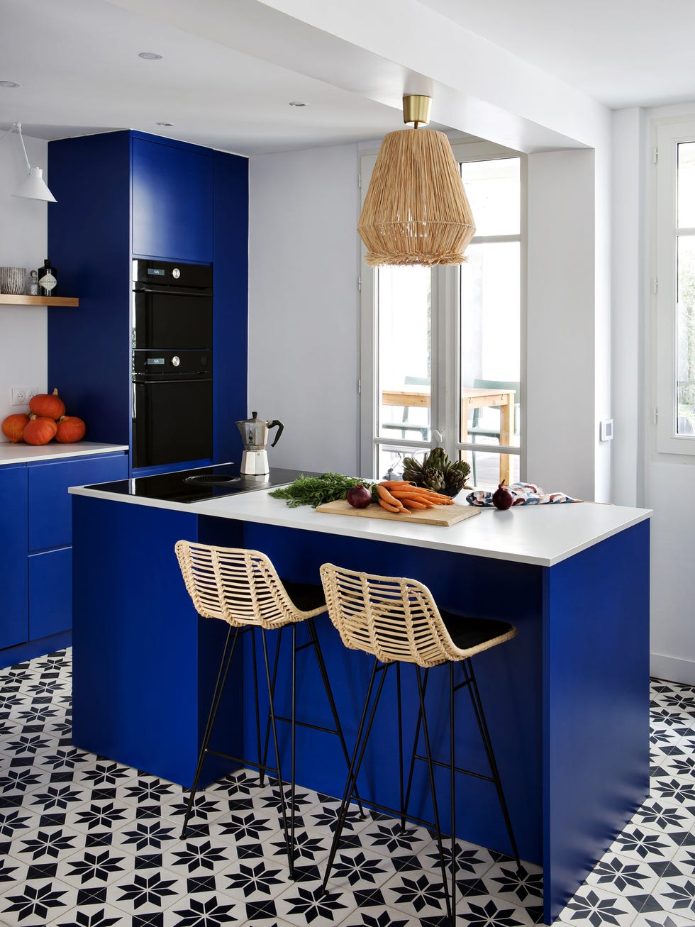 cocina moderna con armarios de color azul, isla central con taburetes y suelo de mosaicos