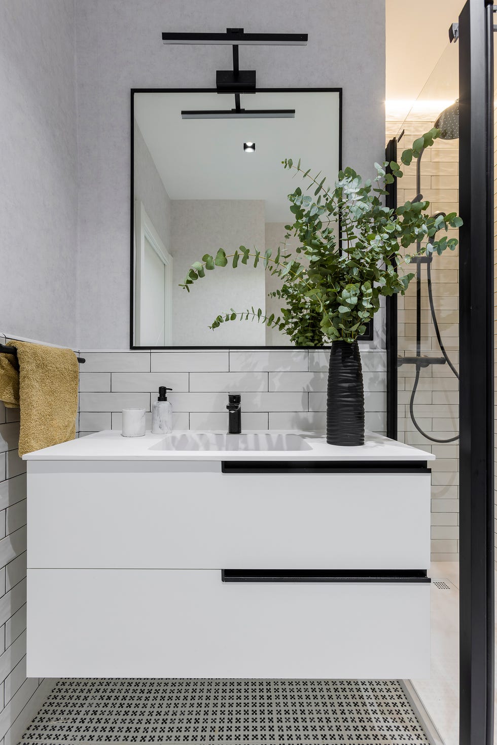 baño moderno con mueble blanco volado y azulejos tipo metro