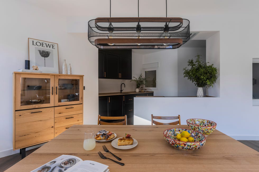 cocina abierta al salón con isla y armarios en madera y color negro