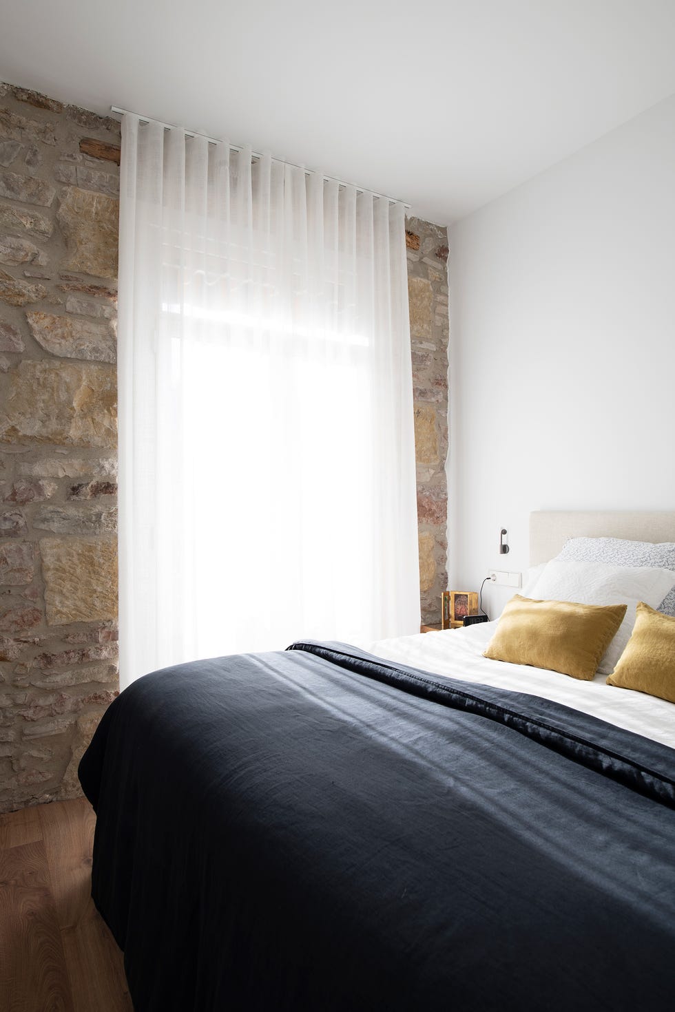 dormitorio con paredes de piedra vista