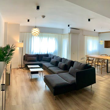 Salón comedor con sofá negro y mesa de madera salón comedor con sofá negro y mesa de madera