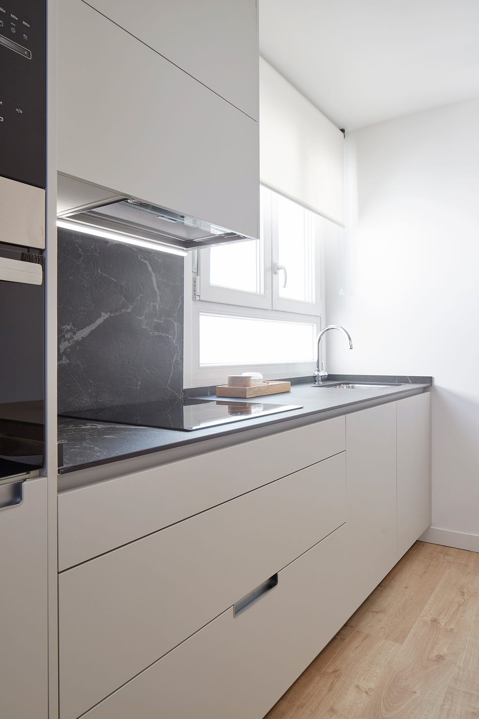 cocina con frentes en gris y encimera tipo mármol negro