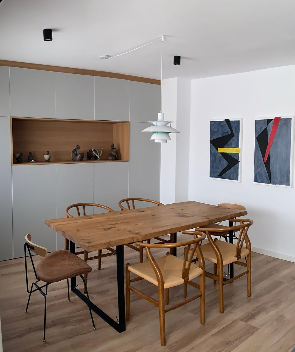 mesa de comedor de madera con patas de acero y sillas wishbone