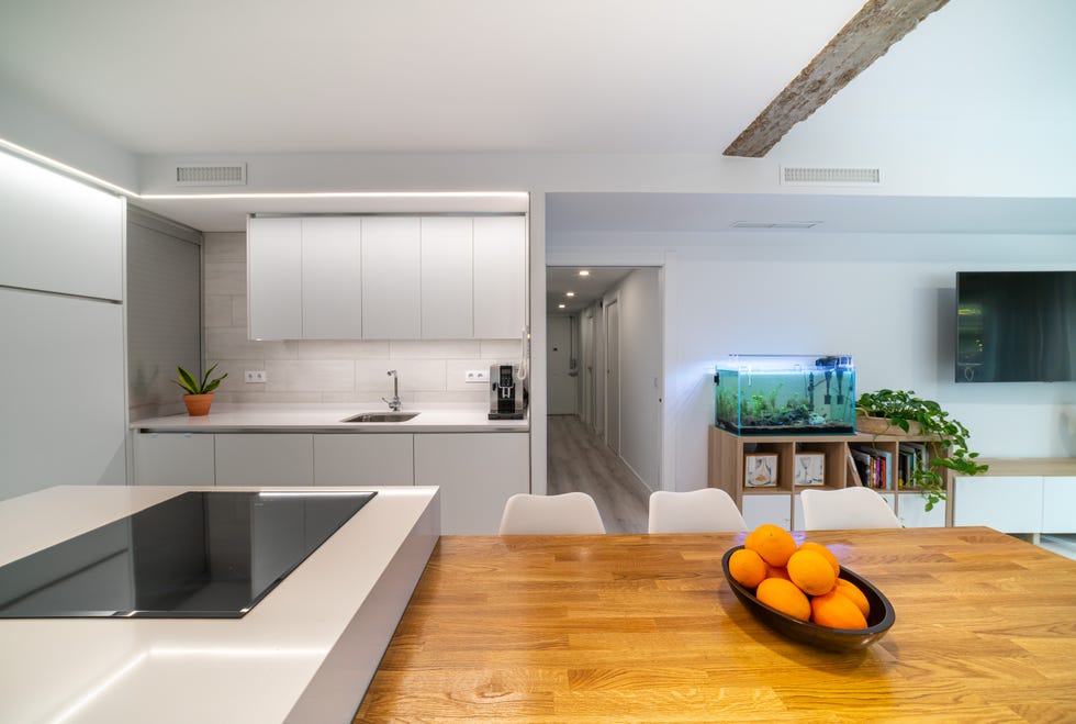cocina blanca con isla integrada en el salón