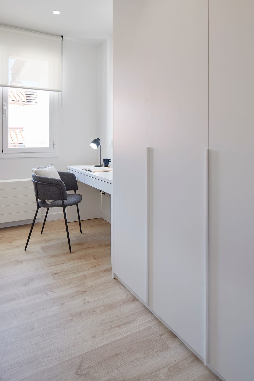 habitación con escritorio y armario blanco