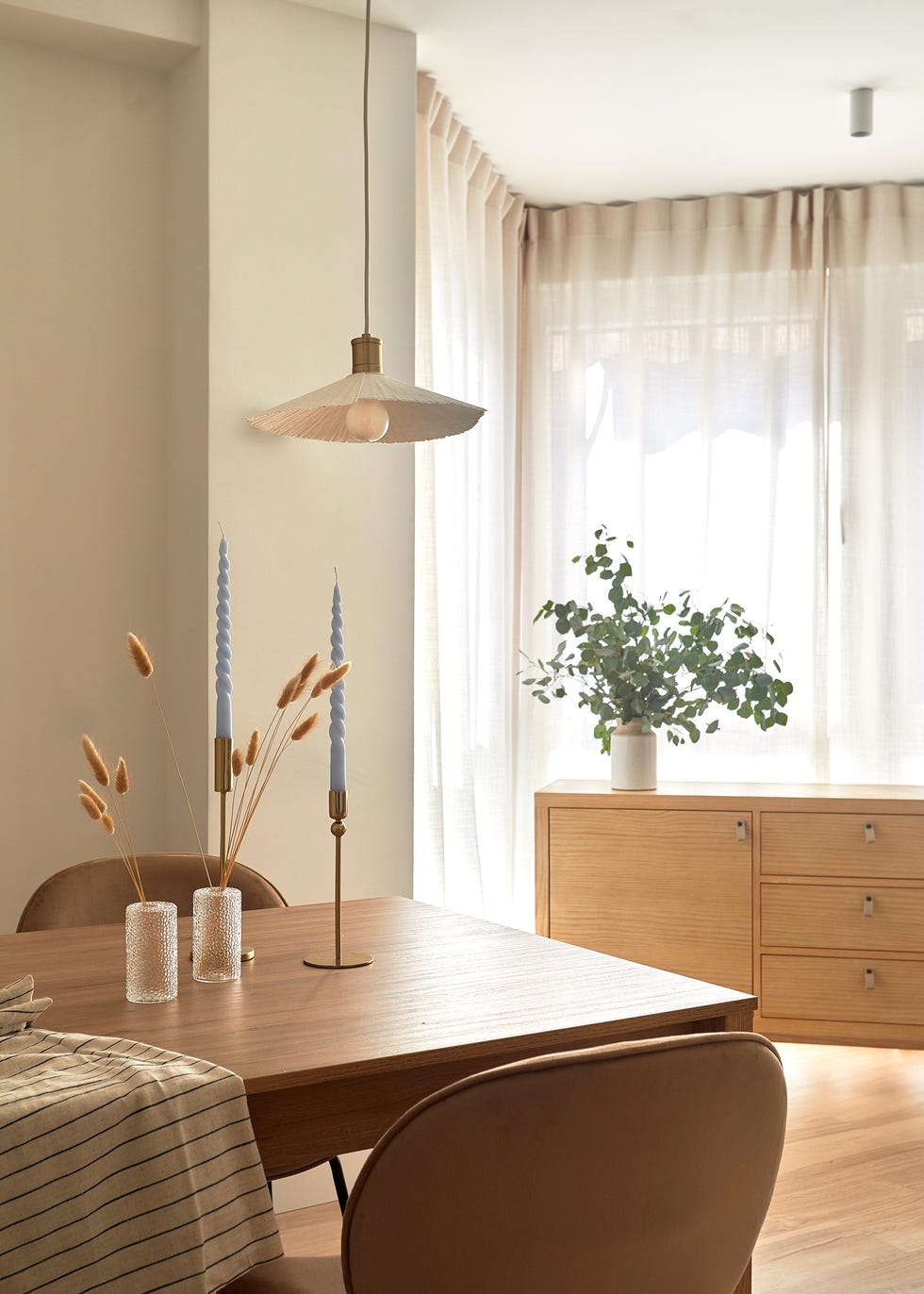 mesa de comedor de madera moderna y sillas de terciopelo en color tierra