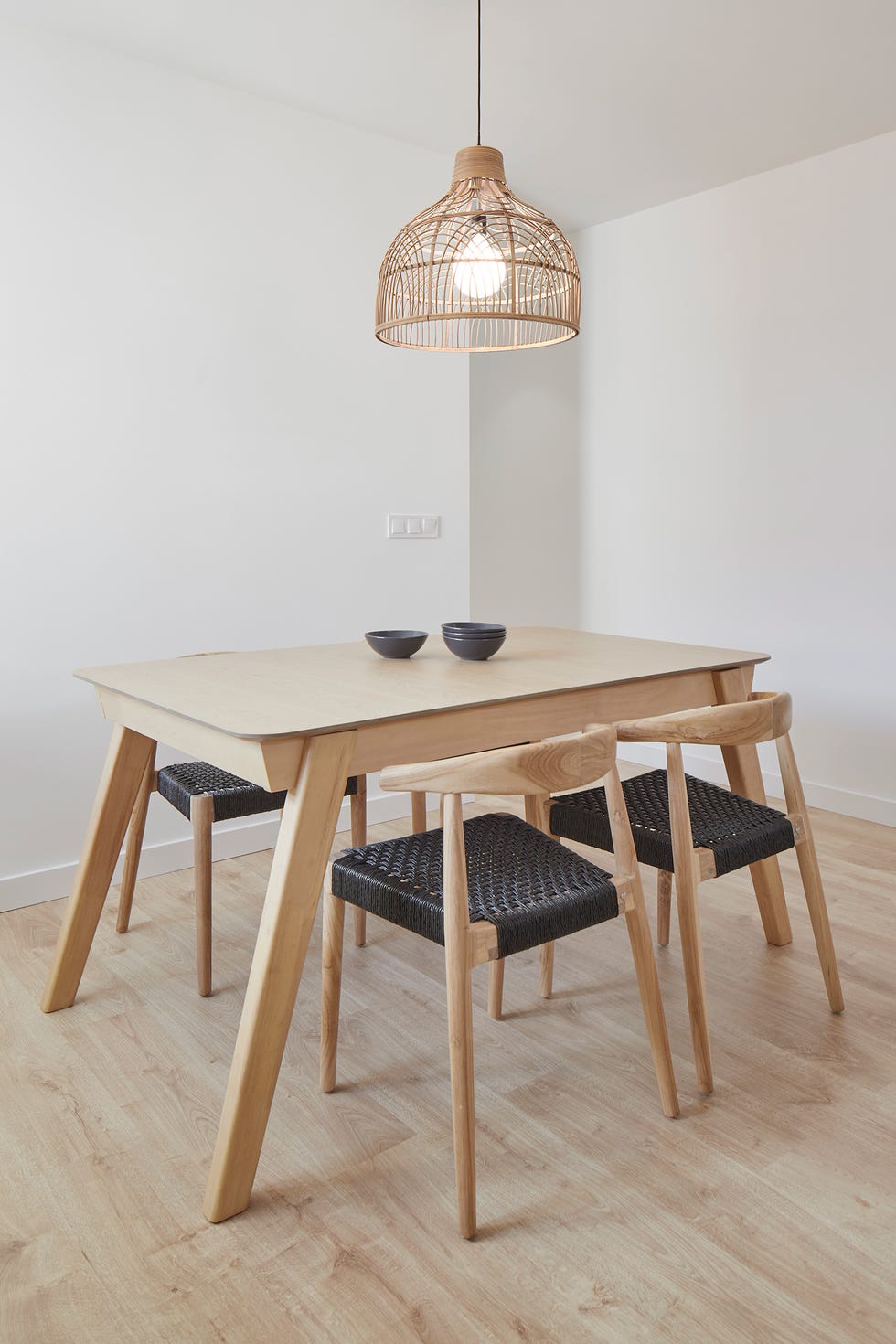 mesa de comedor con sillas de madera y lámpara con pantalla de fibras
