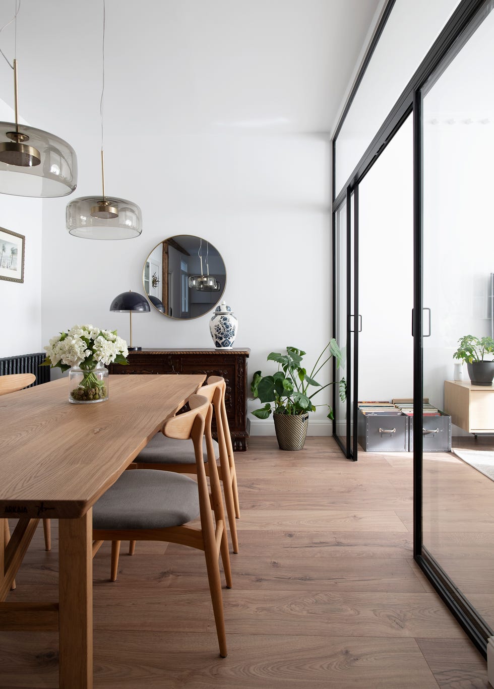 comedor con mesa y sillas de madera y cerramiento de vidrio
