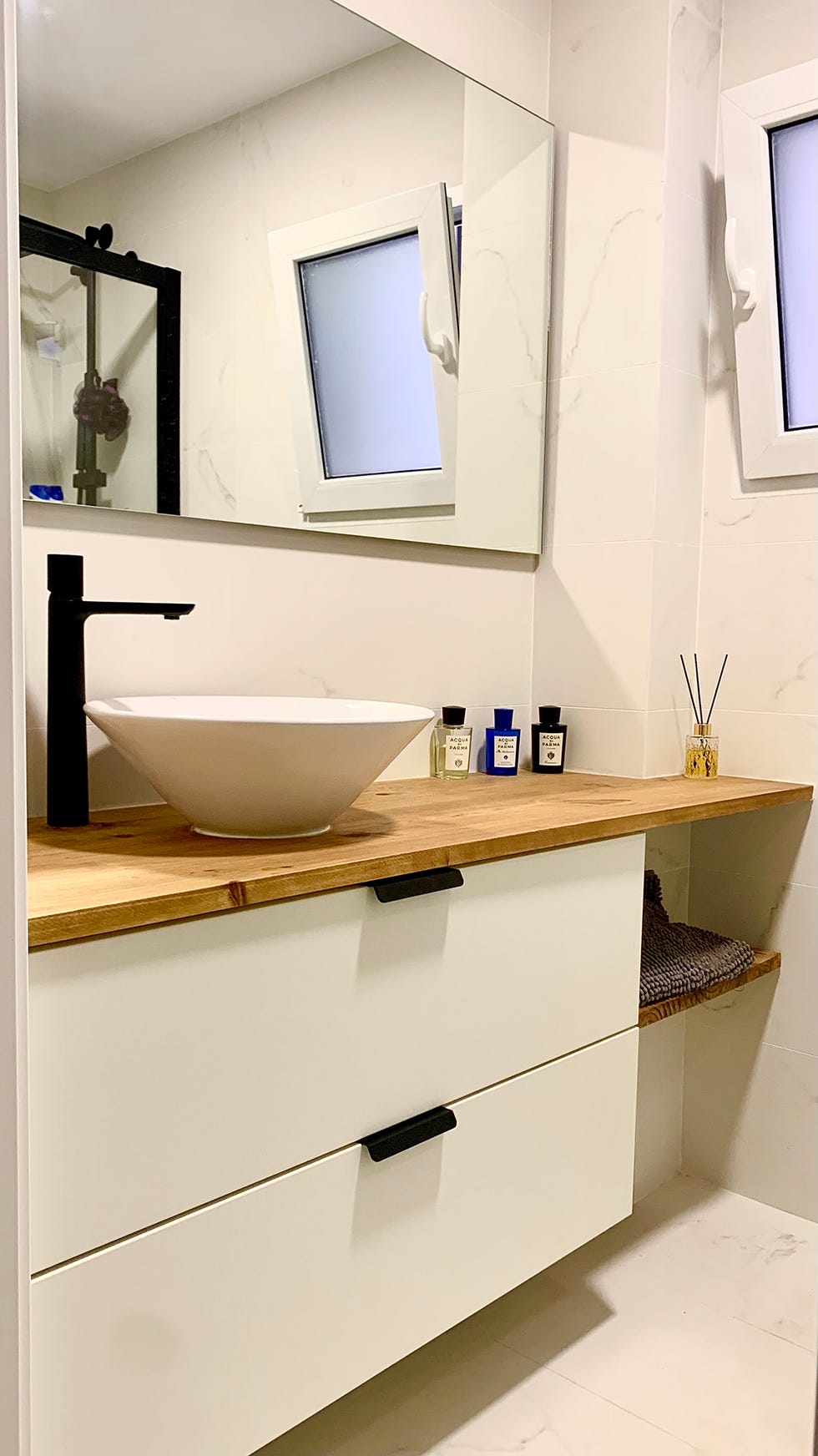baño con mueble blanco volado y encimera de madera