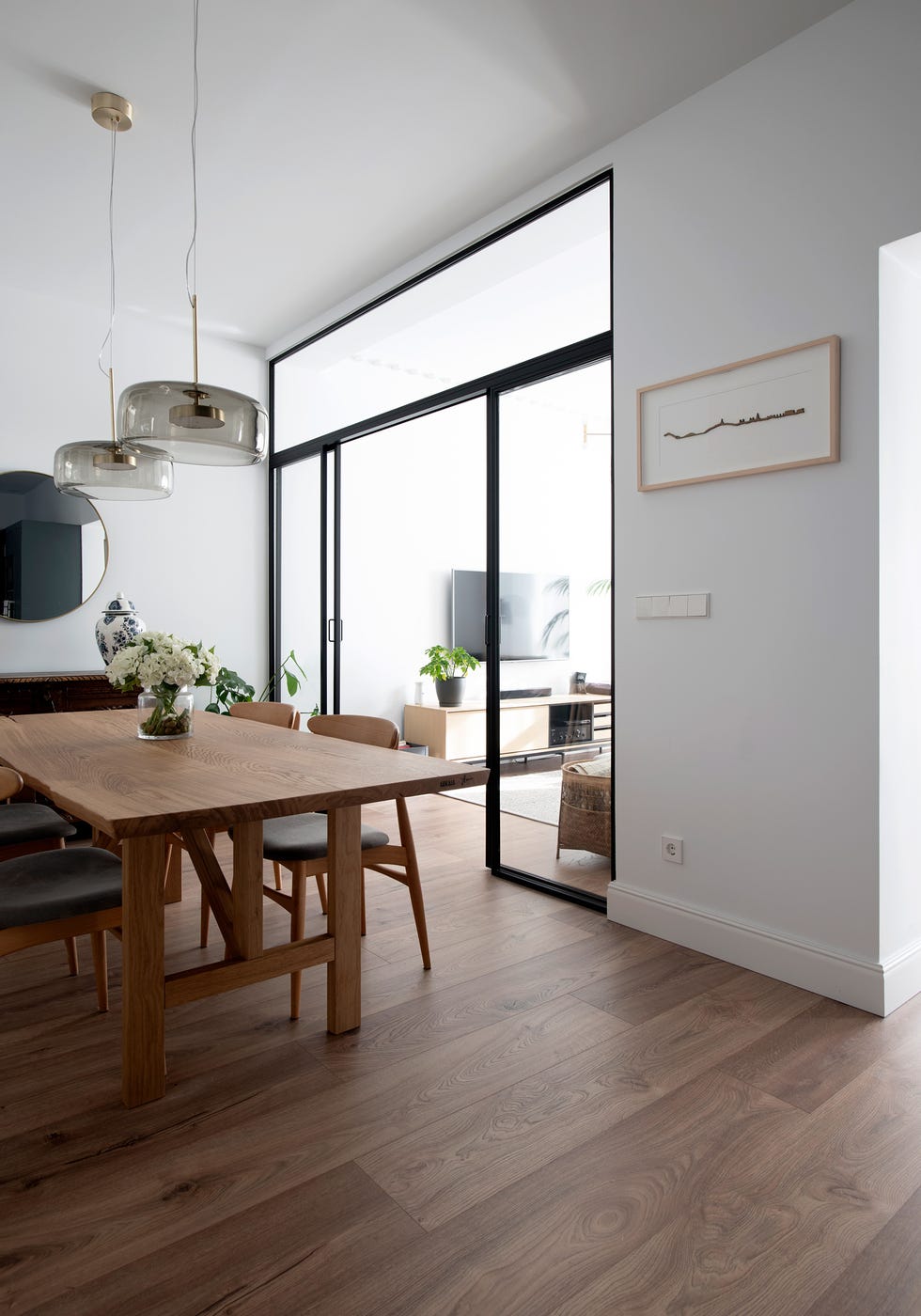 comedor con mesa y sillas de madera y cerramiento de vidrio