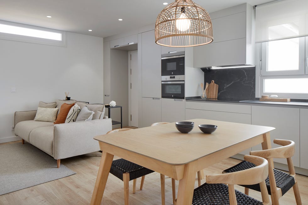 cocina gris con office integrada en el salón con sofá gris de diseño moderno