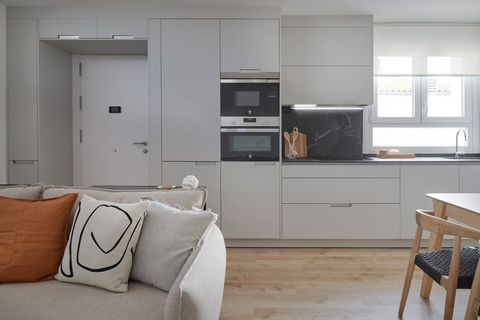 cocina gris integrada en el salón con sofá gris de diseño moderno