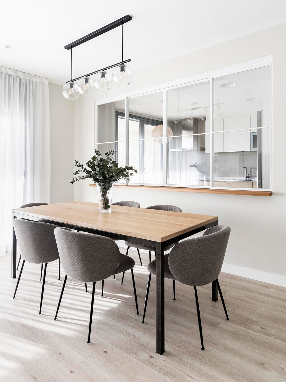 comedor moderno con mesa de madera y acero y sillas nórdicas grises