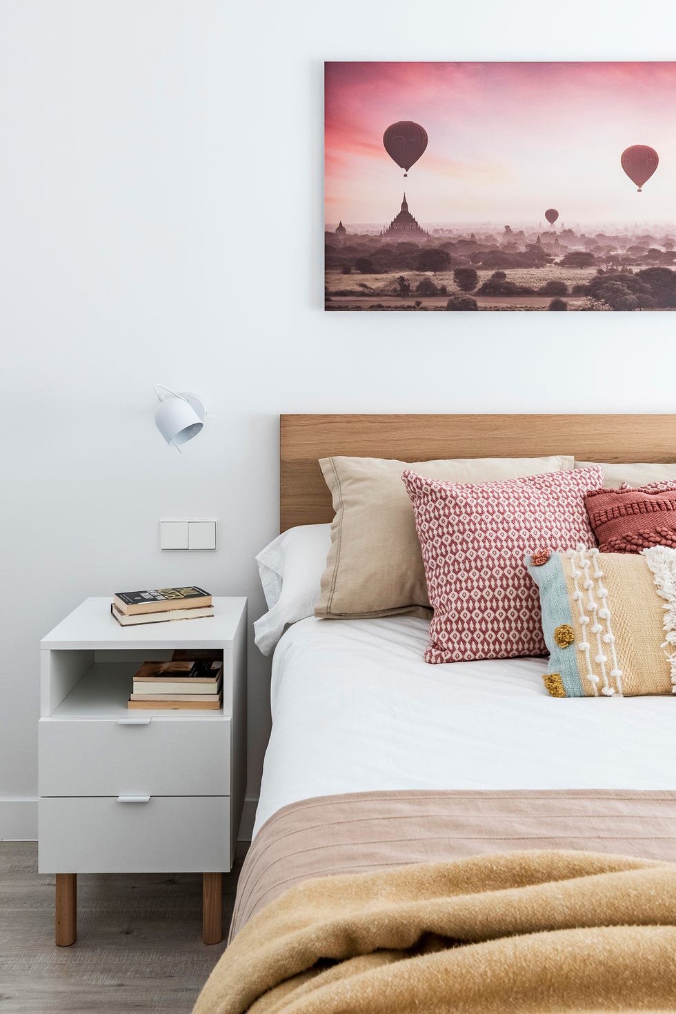 dormitorio con cabecero de madera y mesita de noche blanca